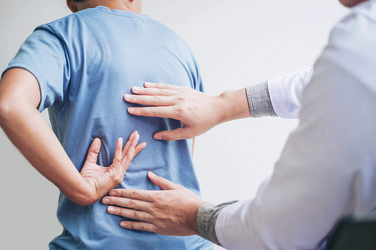 Person receiving chiropractic healthcare for back pain from a healthcare professional.
