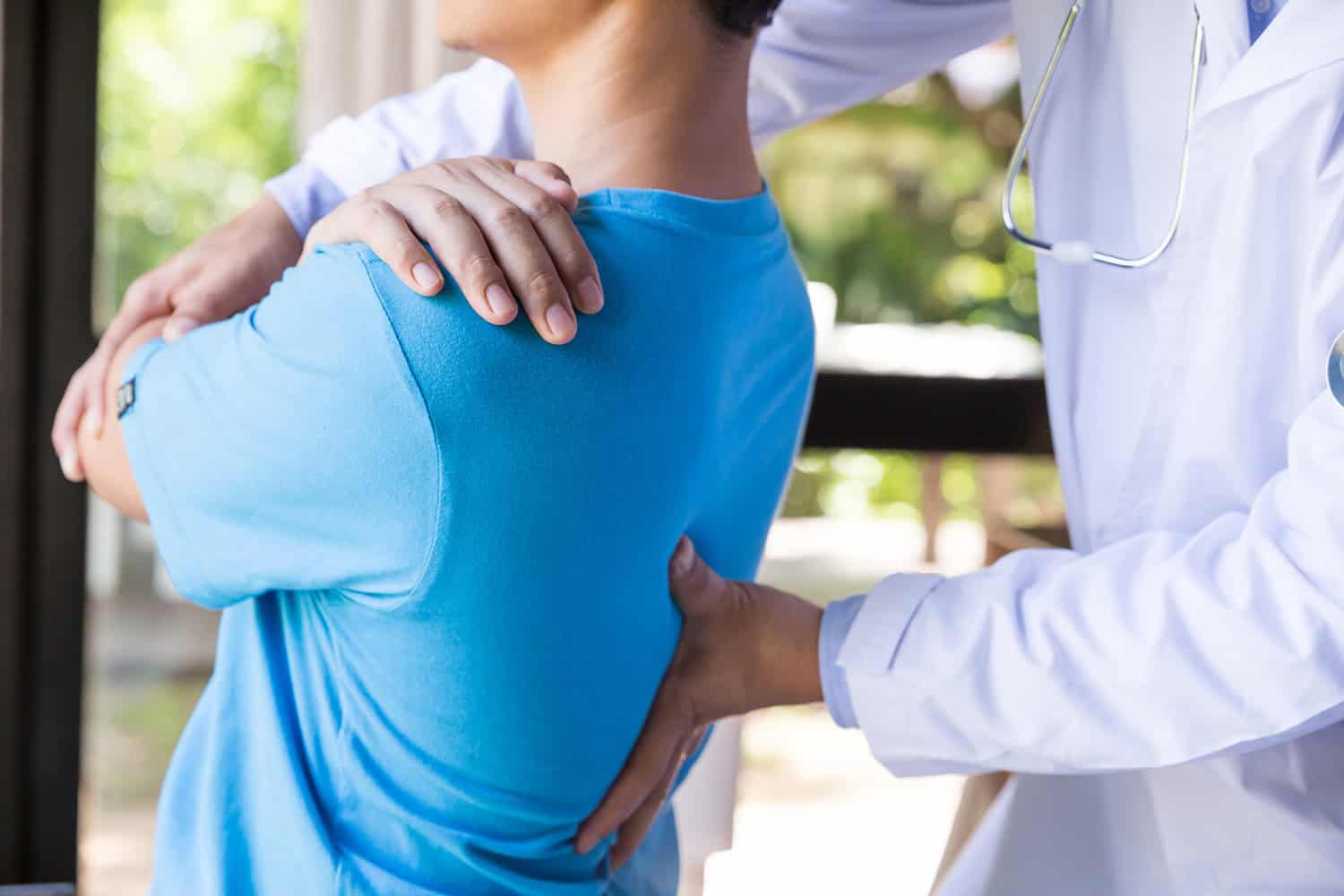 Therapist providing back pain treatment with gentle manipulation and massage.