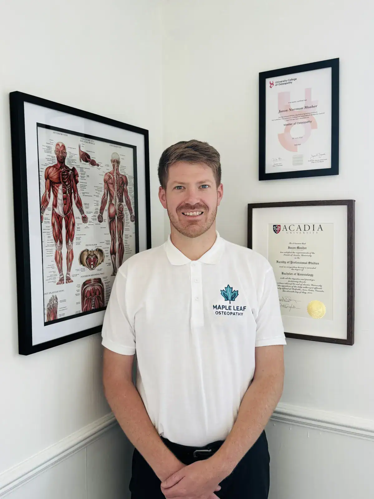 Certified osteopath standing in office with degrees on wall behind him.
